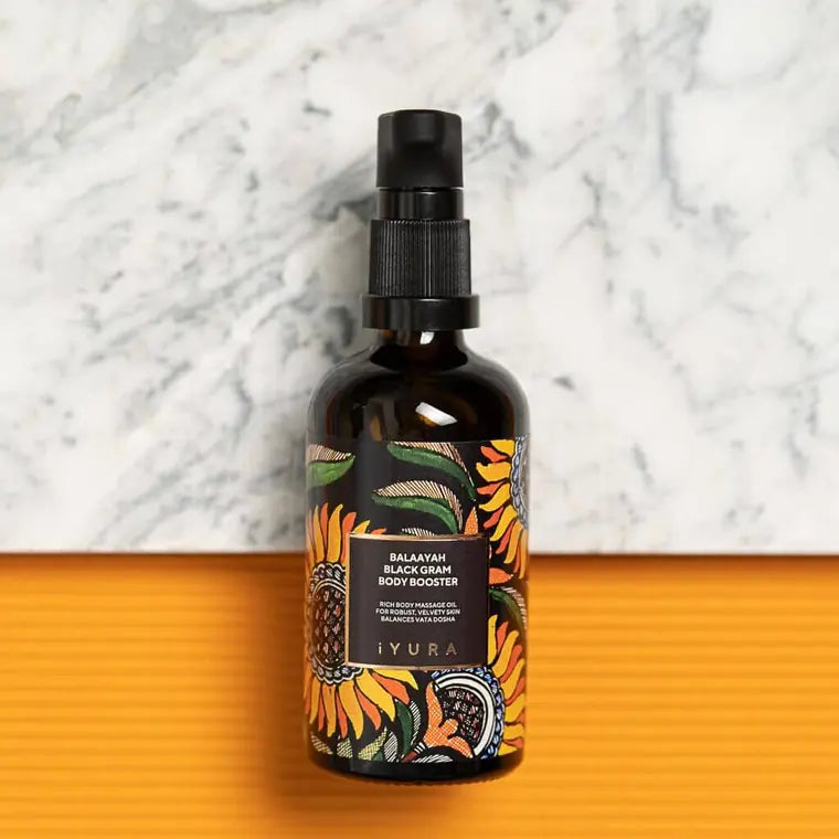 Bottle on marble beside a marigold surface