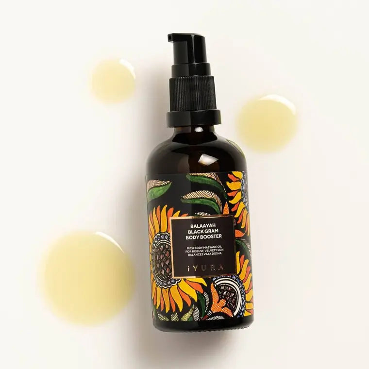 Bottle beside golden droplets of oil